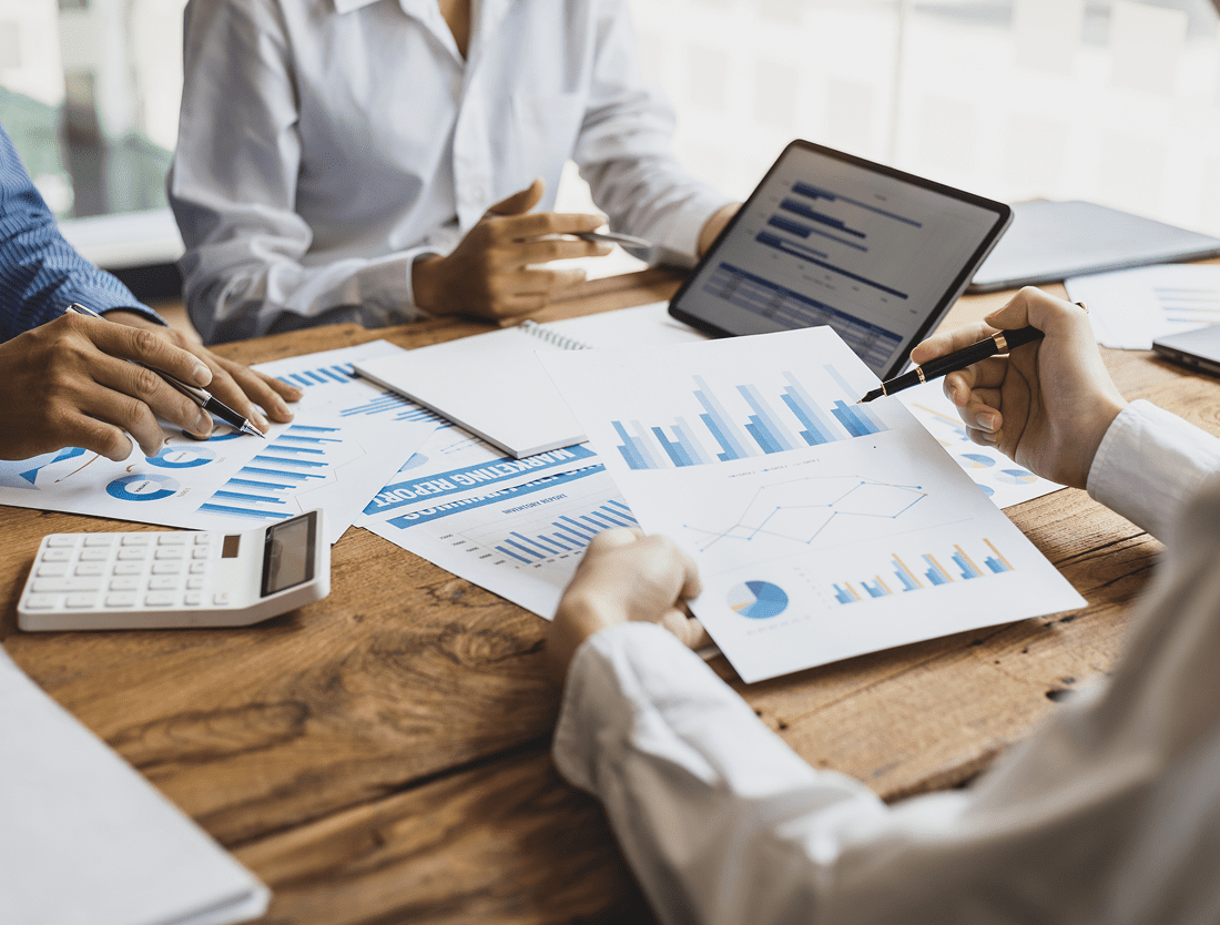 Team analyzing financial reports and data charts in a business meeting.