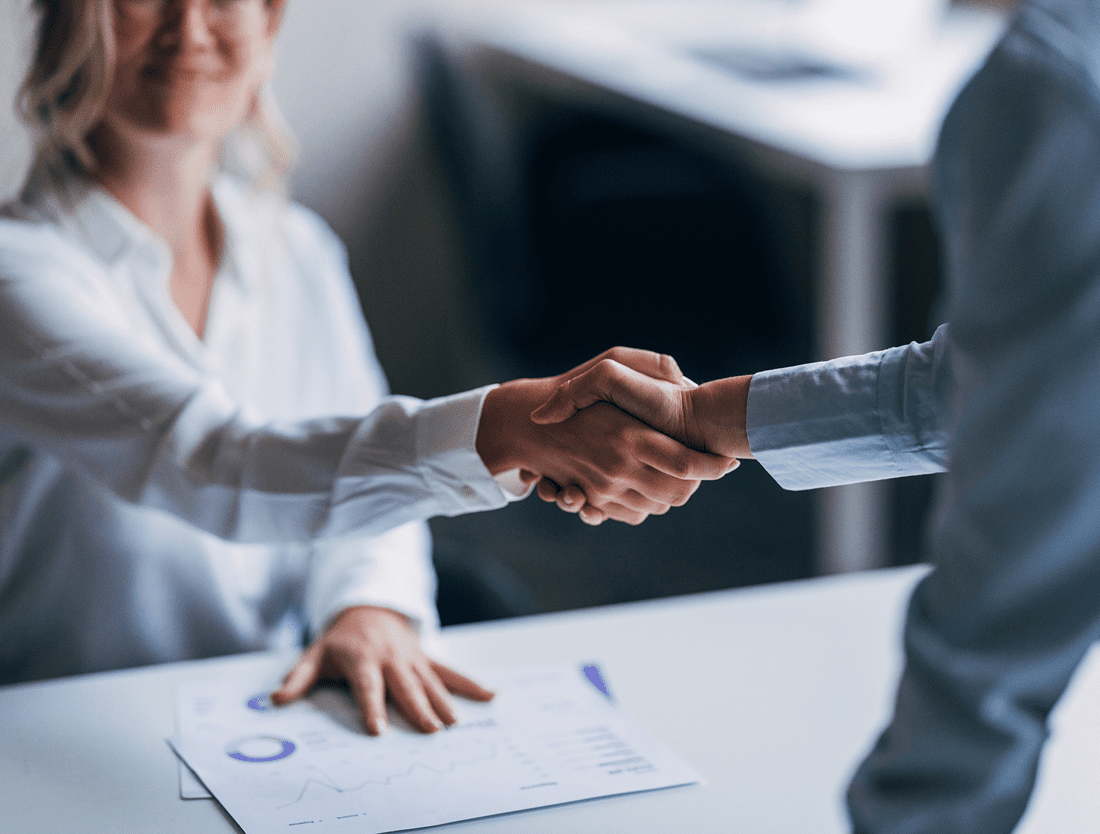 Two professionals shaking hands over a business deal.